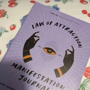 Law of Attraction Manifestation Journal - Säljer en inspirerande journal perfekt för att manifestera dina drömmar och mål. Boken är skapad av en spirituell manifestation coach och är fylld med vägledda övningar. Perfekt för dig som vill utforska attraktionslagen och personlig utveckling. 🌟