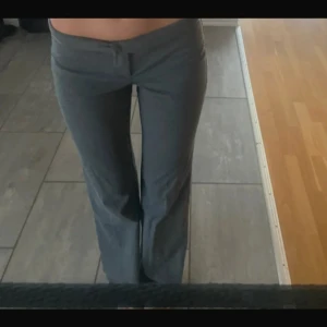 Lågmidjade kostymbyxor - Säljer ett par grå kostymbyxor i bra skick. De har en lågmidjad passform och är i en straight stil. Perfekta för både vardag och lite mer uppklädda tillfällen.