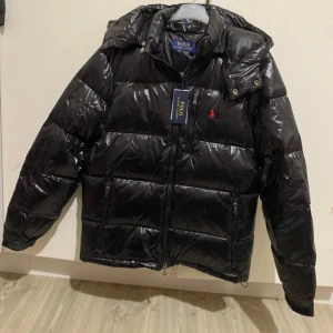 polo ralph lauren jacka - Hej säljer denna Exklusiva och stilrena vinterjackan från Polo Ralph Lauren i svart. Jackan är helt ny och oanvänd, designad för att ge både värme och snygg stil. Ett perfekt val för dig som vill ha en jacka som både är bekväm och ser bra ut hela vintern!