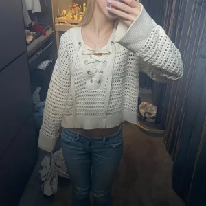 Beige stickad tröja med snörning - Säljer en superfin beige stickad tröja med snygg snörning framtill och vida armar. Den är i jätte bra skick och sparsamt använd💞