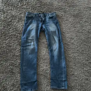 Säljer ett par snygga blå jeans från Replay i modellen Grover. De har en klassisk straight fit och är i bra skick skulle säga 9/10 och dem är använda 5-10 gånger.