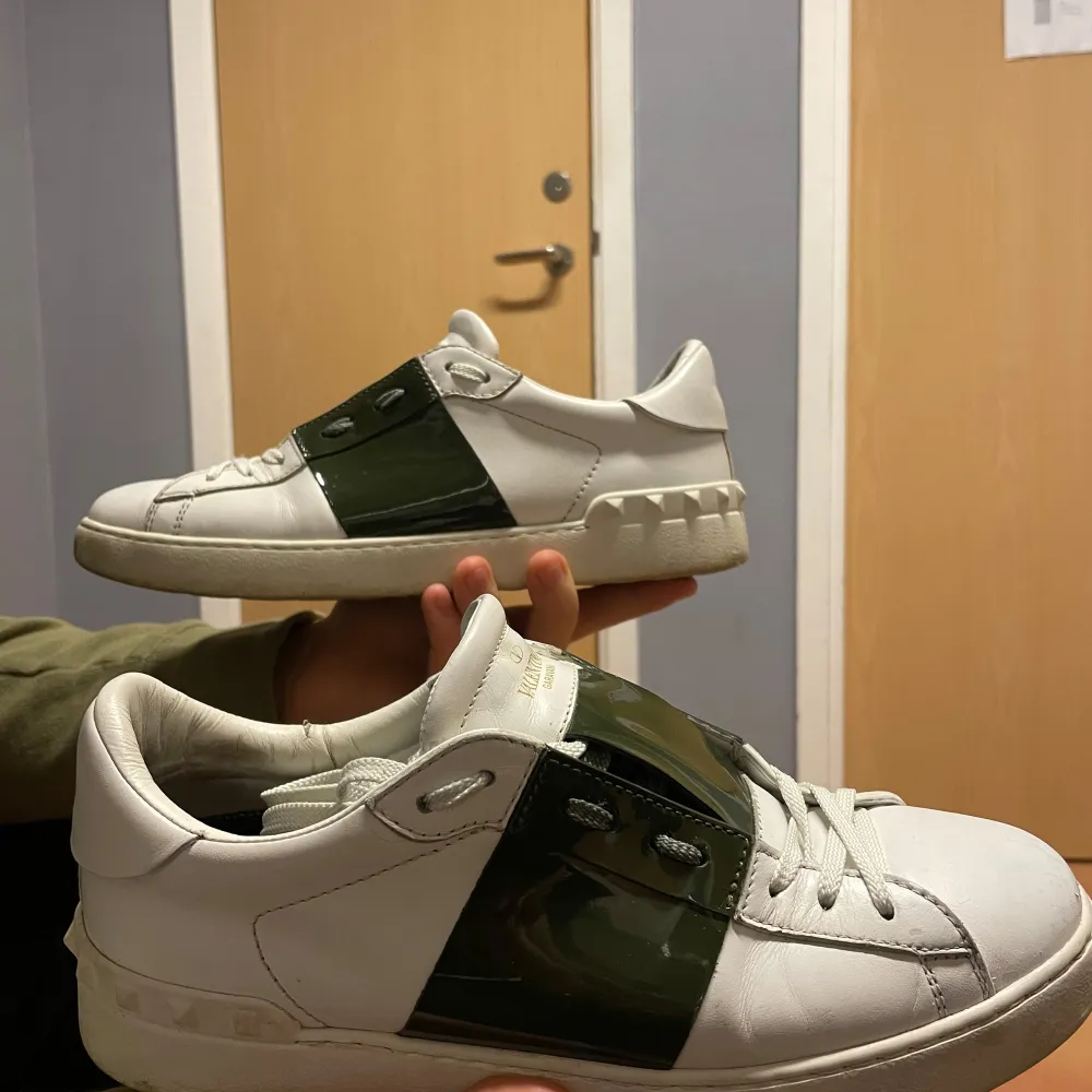 Säljer ett par snygga vita sneakers från Valentino med olivgröna detaljer. Ny pris: 6999, mitt pris: 2400. Passar 40-40,5. Finns valentino kort som äktenskap bevis. Bara att skriva vid funderingar och tankar🤩👍🫡. Skor.