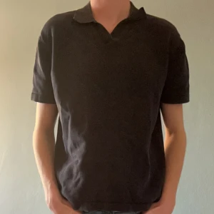 Mörkblå pikétröja - Säljer en klassisk mörkblå pikétröja i bra skick. Den har korta ärmar och en stilren krage. Perfekt för både vardag och lite mer uppklädda tillfällen. Passar bra till jeans eller chinos.