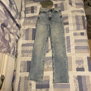 Ljusblå jeans med råa kanter - Säljer ett par ljusblå jeans i bra skick. De har en straight passform och är högmidjade. Jeansen har en cool detalj med råa kanter längst ner, vilket ger dem en avslappnad look. Perfekta för både vardag och fest! 🕺