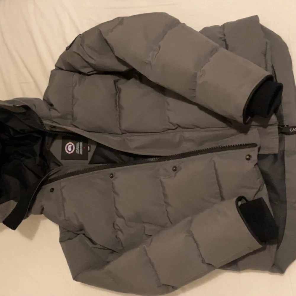 Säljer en grå pufferjacka från Canada Goose i mycket bra skick. Jackan är perfekt för kalla vinterdagar och har en stilren design med dragkedja och långa ärmar. Då den har blivit lite för liten för mig. Jackor.