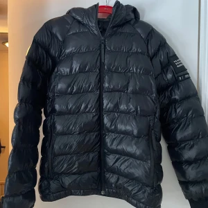 Svart dunjacka från Peak Performance - Säljer en svart dunjacka från Peak Performance i mycket bra skick. Jackan har en normal passform med dragkedja och luva. Jackan är i storlek 170 men sitter som en S/M. Säljer pga kommer inte till användning💗