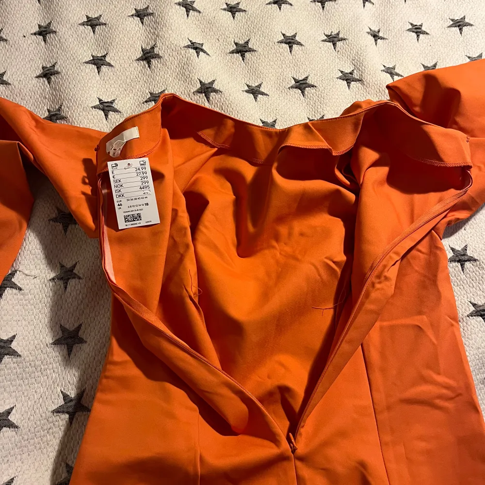 Säljer en snygg orange klänning i storlek 46/XL. Den har en enkel och stilren design med långa ärmar och en dragkedja i ryggen. Perfekt för höst- och vårsäsongen! Helt oanvänd med lappen kvar.. Klänningar.