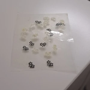Blommiga örhängen i svart och vitt - Säljer ett set med söta blommiga nagelklistermärken i svart och vitt. Perfekta för att ge en extra touch till din outfit. De är små och diskreta, men ändå stiliga och eleganta. Passar både till vardags och fest!