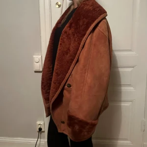 Vinci Italy Röd/brun Shearlingjacka - Supersnygg röd/brun shearlingjacka från Vinci Italy. Jackan är oversized och fodrad med varm päls och har långa ärmar med muddar (som kan vikas ner). Det står ingen storlek i jackan men jag är 175cm lång för referens.