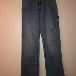 Nya blå cargojeans - Blå cargopants i jeans med flera praktiska fickor. Byxorna har en loose passform och är mycket bekväma i sitt mjuka jeanstyg. Bara använda en enstaka gång.