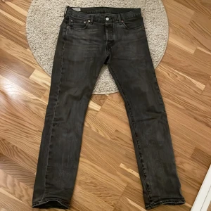 Gråa Levi’s 501 - Säljer ett par riktigt schyssta Levi’s jeans i storlek w30 och l32! Bortsätt från en liten slitning i ena hälen som inte märks vid användning så är dem perfekta. De matchar med allt men är tyvärr lite väl tighta i midjan för mig vilket gör att någon annan kan komma till bättre användning av dem.