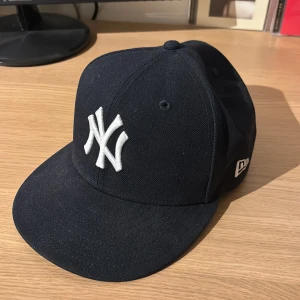 Mörkblå New Era Keps - Mörkblå keps i bra skick. Säljer då den inte passar.