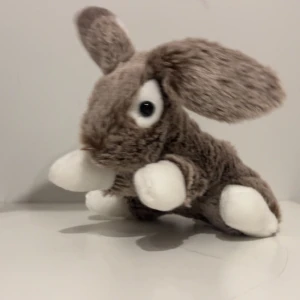 Brun och vit kaninmjukisdjur - En söt och mjuk kaninmjukisdjur i brunt och vitt. Den har stora öron och en gullig liten nos. Perfekt som en kramgo kompis eller dekoration i rummet.