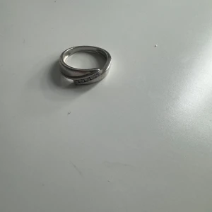 Silverring med stenar - Elegant silverring med en rad av små gnistrande stenar infällda i en böjd design. Perfekt för att lägga till en touch av elegans till vilken outfit som helst.åkta silver