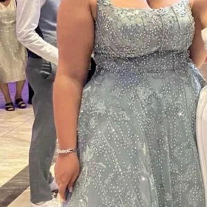 Glittrig grå långklänning - Säljer en fantastisk glittrig blå/grå långklänning med pärldetaljer. Klänningen har en elegant passform. Säljes nu för 3500kr (köpt för 8000kr) i storlek 44 (funkar som en 42) , använd 1 gång i några timmar.  