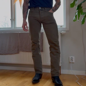 Olivgröna Levis  - Snygga olivgröna 501or. . Byxorna har en klassisk design med dragkedja och knappar. Perfekta för en stilren look.