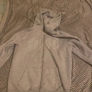 Tuttolente zip hoodie - Säljer en grå hoodie från tuttolente med dragkedja och tryck på bröstet. Den har en stor huva och en cool design på ryggen. Den är i bra skick men den e använd. Pris är diskuterbart vid snabb affär