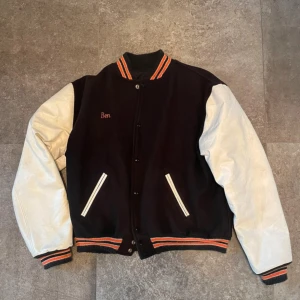 Vintage Varsity-/Collegejacka - Storlek XL men sitter som en L på mig (186cm), ärmarna är gjorda i vinyl. Jackan är gjord i ull, nylon och polyester och insidan är fodrad så den är varm att ha även på vintern.  Använd men fortfarande i väldigt fint skick. Mått: Axelbredd (57cm), Längd (67,5cm), Armlängd (71cm)
