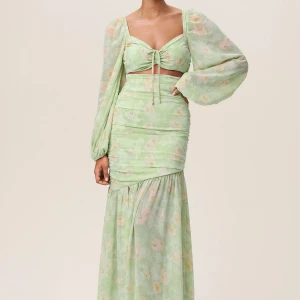 Grön blommig långklänning - Säljer en vacker grön långklänning med blommigt mönster och långa ärmar från adoore. Den är helt oanvänd med lappar kvar, nypris 1795. Perfekt för sommarens festligheter!💚