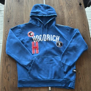 Hoodrich Pacific Hoodie Herr - Säljer en snygg blå hoodie från Hoodrich med coola patches och broderade detaljer. Den har en stor känguruficka och justerbar huva med snören. Hör av er om ni har frågor.
