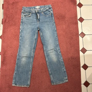 Blå jeansbyxor - Klassiska blå jeansbyxor med en rak passform. De har fem fickor och en dragkedja med knappstängning. Perfekta för en avslappnad stil.