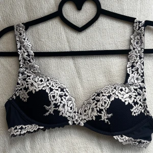 Intimissimi bh push-up - Sparsamt använd mörkblå bh med push-up och spets . Justerbara axelband och en klassisk knäppning bak i 4 lägen. Hel o ren, använd fåtal tillfällen. 