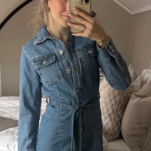 Jeansklänning från zara🤍 slutsåld på hemsidan! - Säljer nu denna trendiga och helt slutsålda jeansklänning från Zara! Jeansklänning med knappar framtill och ett matchande bälte i midjan. Endast använd en gång, nytt skick🤍