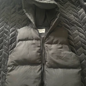 Svart dunväst från NA-KD - Snygg svart dunväst från NA-KD storlek 34, knappt använd så superfint skick!! 