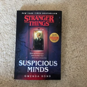 Suspicious Minds - Boken 'Suspicious Minds' av Gwenda Bond är den första officiella 'Stranger Things'-romanen. Den utspelar sig sommaren 1969 och utforskar hemligheterna bakom Elevens mamma och de mystiska experimenten i Hawkins. Perfekt för fans av serien som vill fördjupa sig i dess bakgrundshistoria. Skriven på engelska