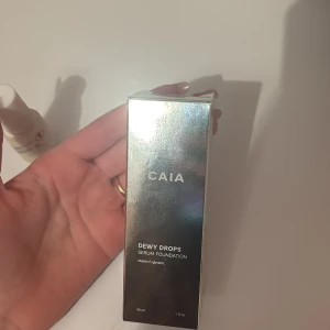 OANVÄND Dewy Drops Serum Foundation från CAIA 2c  - Dewy Drops Serum Foundation från CAIA med vitamin E ger en jätte fin naturlig finish och lägger sig som hud. Går och bygga upp täckningen, säljer för ja har köpt fel färg, oöppnad förpackning o kvittot e kvar. Färg:2c går o diskutera pris 