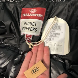Äkta!! Parajumper jacka ny - Säljer en jacka från Parajumpers den är köpt på nk. Säljer den för att jag har en annan stil och den är köpt för 6700kr den är använd 2 ggr. Jackan har en glansig finish och är utrustad med dragkedja och en gul detalj vid kragen. Perfekt för kyligare dagar och ger en cool look. 🖤