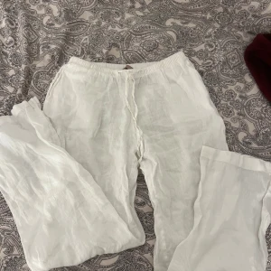 Vita linnebyxor i storlek XS - Säljer ett par vita linnebyxor i storlek XS. Byxorna har en avslappnad passform med snöring. Perfekta för varma sommardagar.
