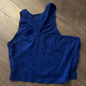 Blå ribbad linnetopp - Snygg blå ribbad linnetopp med ärmlös design. Perfekt för en avslappnad stil. Toppen har en enkel och stilren look.