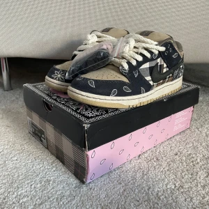 Travis Scott Nike SB Dunk Low - Säljer ett par Travis Nike SB Dunk Low med friends & family boxen. Svarta å rosa extra snören följer med också!