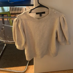 Beige tröja från Vero Moda - Säljer en stilren beige tröja från Vero Moda. Tröjan har puffiga ärmar och en rund halsringning. Perfekt för en avslappnad och trendig look. Passar bra till både jeans och kjol.