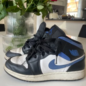Nike Air Jordan i svart, vit och blå - Snygga Nike Air Jordan sneakers i svart, vit och blå. Skorna har en klassisk design med snörning och den ikoniska Air Jordan-loggan på sidan. Har använts ett par gånger, men kommer inte till användning för storleken är för liten för mig💙💙