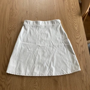 Vit kjol från NLY One - Snygg vit kjol från NLY One i en klassisk A-linjeform. Perfekt för en stilren look. Kjolen är i en mjuk och bekväm polyesterblandning.