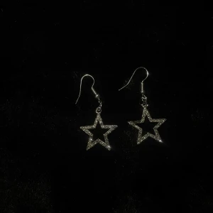 Stjärnformade örhängen i silver - Handgjorda snygga stjärnformade örhängen i silver med glittrande detaljer. Perfekta för att ge en extra touch till din outfit. De har en enkel krok för enkel användning.