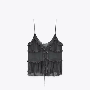 Topp med volanger från Zara - Snygg svart ärmlös topp från Zara med tunna axelband och volangdetaljer. Toppen knyts  framtill och är i ett lätt och luftigt material. Endast använd en gång, säljer pågrund av den har blivit för liten. storlek L, men upplevs mindre mer S-M