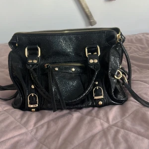 Så fin väska - Snygg svart handväska med glittrig yta och gulddetaljer. Den är köpt i Italien förra året för 800 kr och den är endast använd 1 gång