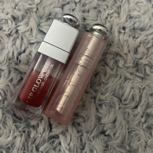 Läppglans och läppbalsam från Dior - Säljer ett set med Dior Lip Glow Oil och Dior Lip Glow. Lip Glow Oil har en härlig körsbärsolja och ger en glansig finish. Lip Glow är ett återfuktande läppbalsam med en lätt rosa nyans. Båda produkterna har elegant förpackning med silverdetaljer.Lipoil 012 och läppstift 001.Lipoil har 70% i sig läppstift har 95%.‼️TAR ENGAST EMOT SWISH TRYCK INTE PÅ KÖP NU‼️(priset är fast)