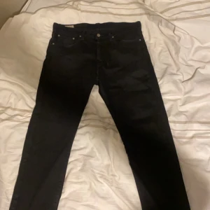 Svarta jeansbyxor - Snygga svarta jeansbyxor med klassisk design. De har en rak passform och är perfekta för en stilren look. Byxorna har fem fickor och knappgylf.