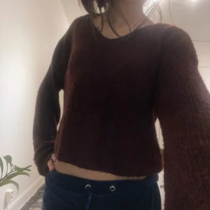 Brun stickad tröja - Säljer en mysig brun stickad tröja med v-ringning. Tröjan är croppad och har långa ärmar, perfekt för kyligare dagar. 