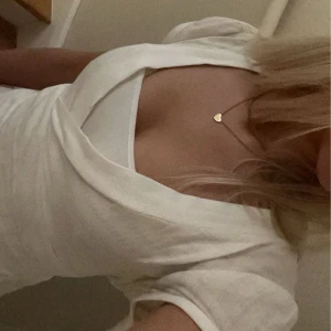 Vit omlottopp - Säljer en jättefin vit omlottopp med guld ränder. Den har korta ärmar och ett knyt där back. Toppen är V-ringad och passar till allt! Den går att använda året runt och är lätt att klä upp och ner. För fler bilder eller frågor är det bara att skriva💖