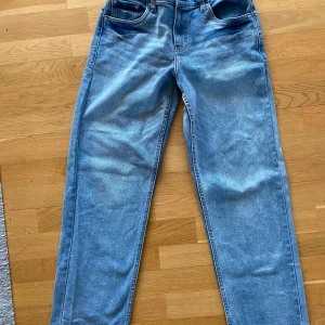 Blå jeans från Levi's - Säljer ett par snygga blå jeans från Levi's med loose taper passform. De har klassisk femficksdesign och en bekväm midja. Perfekta för en avslappnad stil.