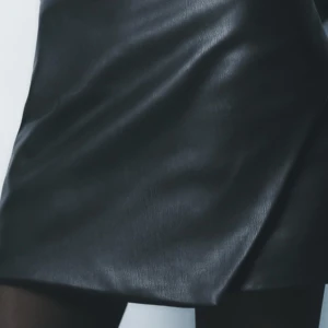 Svart skinn kjol från Zara med omlott-design - Jätte snygg skinn kjol/shorts från Zara. Aldrig använda i storlek medium, pris kan diskuteras. Skriv privat för fler bilder🩷🩷