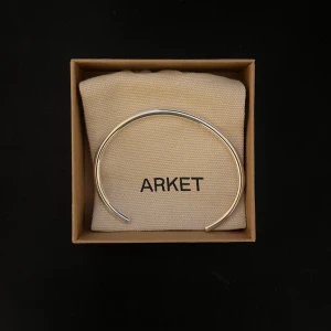 armband från Arket - Stilrent och minimalistiskt armband i silver från Arket. Perfekt för att ge en elegant touch till din outfit. Armbandet kommer i en snygg förpackning och är lätt att matcha med andra smycken.