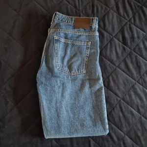 Blå jeansbyxor - Klassiska blå jeans med en rak passform och femficksdesign. Perfekta för en avslappnad stil. De har en midwaist och är tillverkade i slitstarkt denim.
