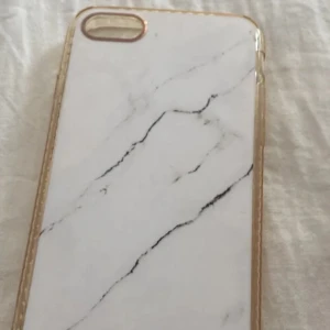 Mobilskal  - Snyggt mobilskal med marmormönster i vitt och svart. Skalet har en transparent kant som ger en stilren look. Perfekt för att skydda din mobil med stil.