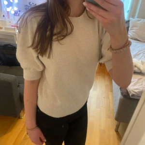 Vit beige tröja med volang ärm  - Stickad vit beige tröja med volang ärm från Vero Moda i storlek xs, men passar s lika bra. Använt några gånger men ör i väldigt bra skick